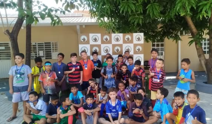 Vista ampla do pátio com participantes em atividade esportiva.